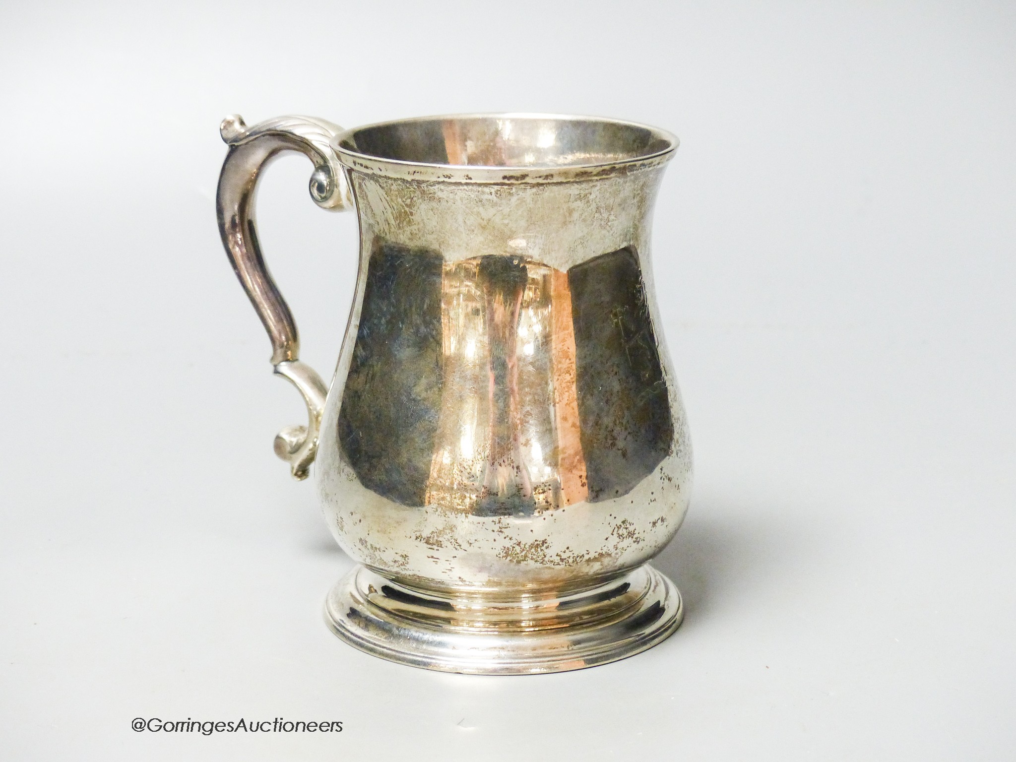 A George II silver baluster mug, with acanthus leaf capped handled and engraved crest, Henry Brind, London, 1743, height 11.7cm, 11.5oz.